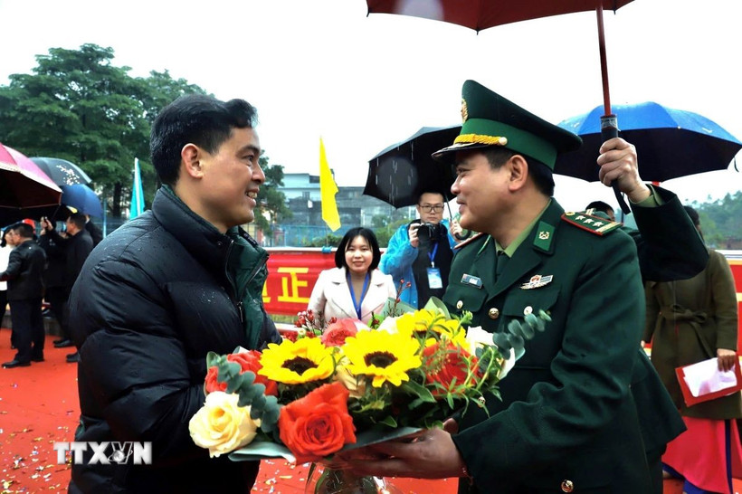 Lãnh đạo Biên phòng Hoành Mô (Quảng Ninh) tặng hoa chúc mừng các du khách nhập cảnh. (Ảnh: TTXVN phát)