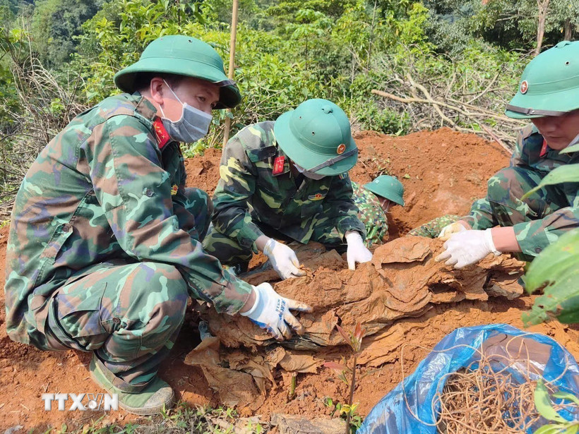 Hài cốt liệt sỹ được phát hiện ở độ sâu 1m với nhiều di vật kèm theo. (Ảnh: TTXVN phát)