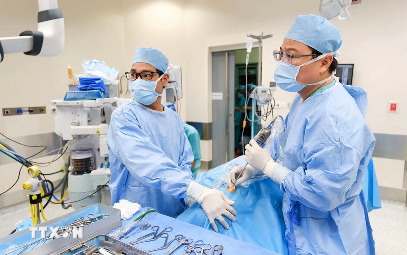 Các bác sỹ Bệnh viện FV tiến hành phẫu thuật dẫn lưu ápxe và nạo sạch ổ nhiễm trùng cho bệnh nhi. (Ảnh: TTXVN phát)