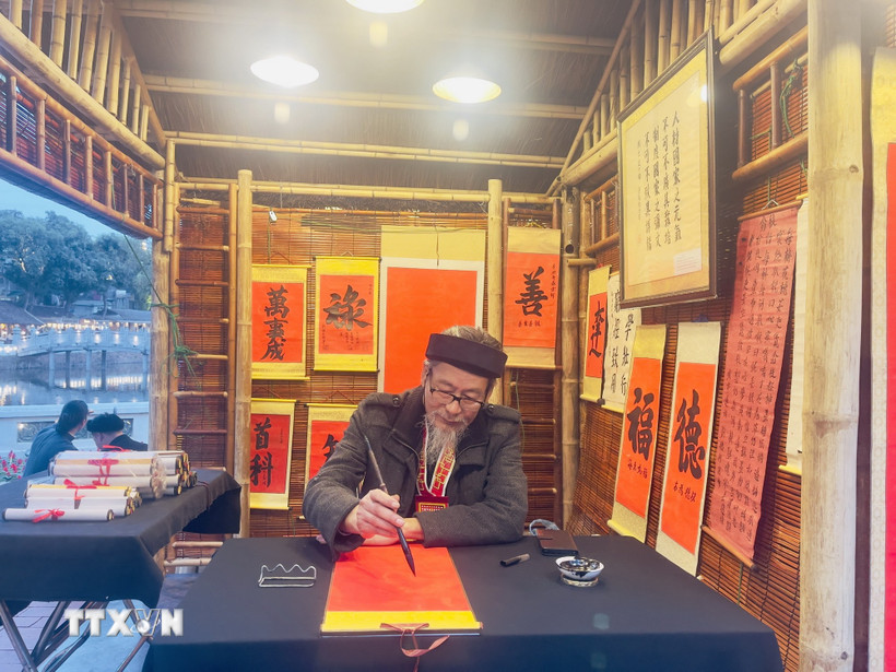 Ông đồ cho chữ tại Hội chữ Xuân Bính Ngọ 2026 trong không gian Hồ Văn, di tích quốc gia đặc biệt Văn Miếu-Quốc Tử Giám. (Ảnh: Tuyết Mai/TTXVN)