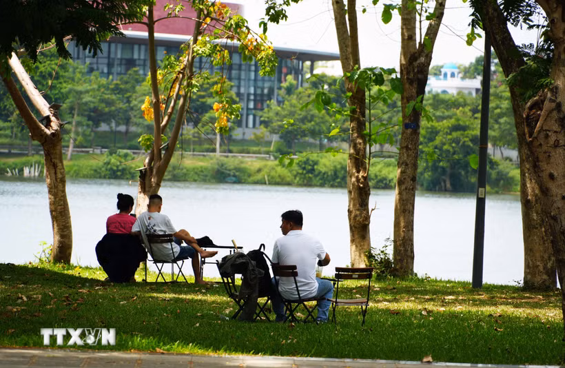Người dân đến công viên bờ Bắc sông Hương, thành phố Huế để hóng mát, tránh nắng nóng gay gắt. (Ảnh: Nguyên Lý/TTXVN)