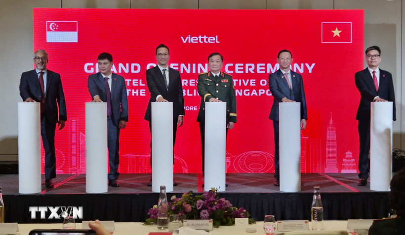 Thượng tướng Hoàng Xuân Chiến (thứ 3 phải sang), Ủy viên Thường vụ Quân ủy Trung ương, Thứ trưởng Bộ Quốc phòng cùng các đại biểu bấm nút khai trương Văn phòng Đại diện Viettel tại Singapore. (Ảnh: Việt Dũng/TTXVN)