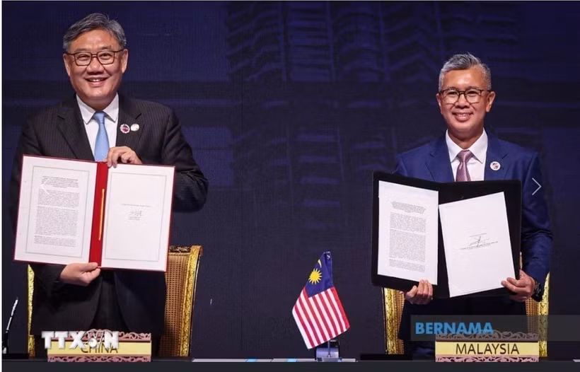 Bộ trưởng Đầu tư, Thương mại và Công nghiệp Malaysia Zafrul Aziz (phải) và Bộ trưởng Thương mại Trung Quốc Vương Văn Đào (trái) sau khi ký ACFTA 3.0. (Ảnh: TTXVN phát)
