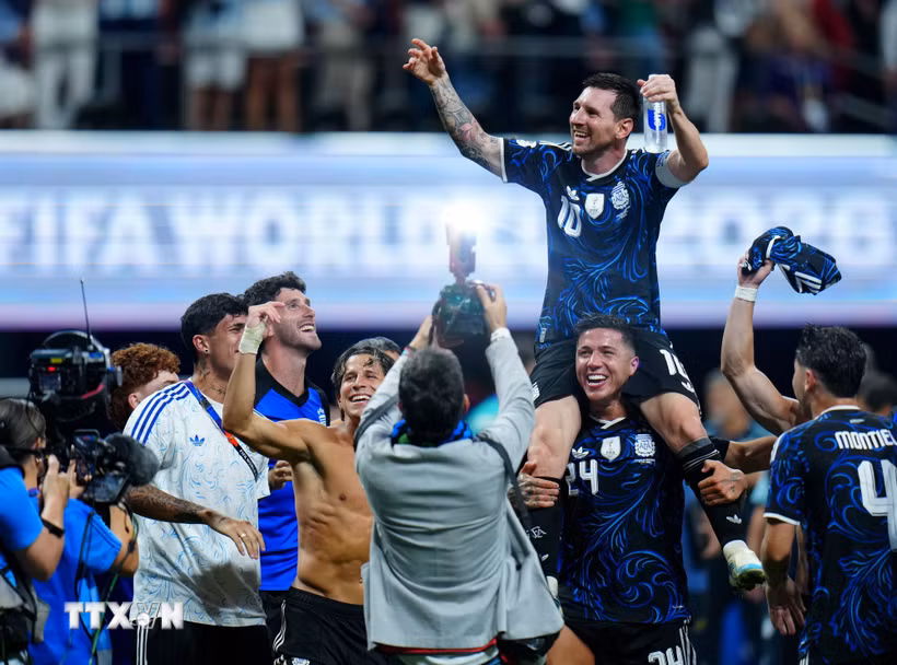 Niềm hạnh phúc của Messi (phía trên) khi lập cú đúp kiến tạo để đồng đội ghi bàn, giành chiến thắng ngược dòng ngoạn mục 2-1 trước tuyển Anh. (Ảnh: THX/TTXVN phát)