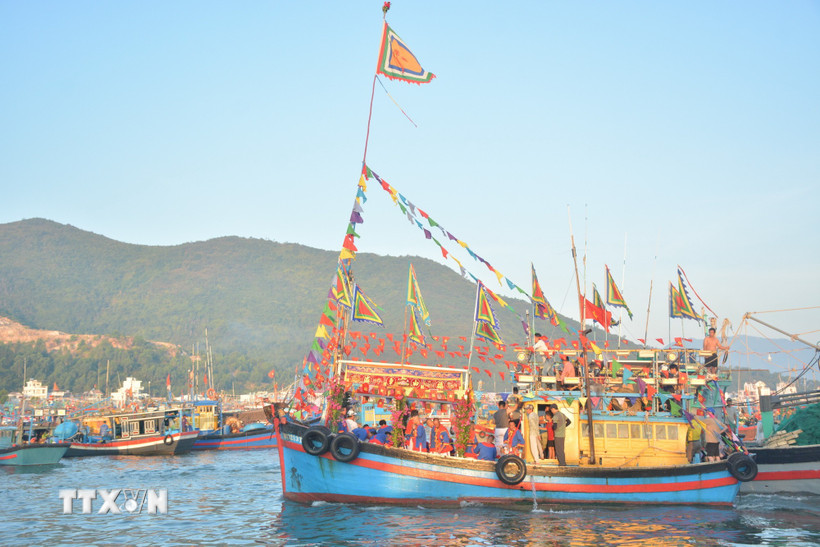Mở đầu lễ hội là nghi thức nghinh Ông trên biển. Từ sáng sớm, đoàn ghe được trang hoàng cờ hoa rực rỡ xuất phát từ bến cá Vĩnh Trường, tiến ra khu vực mũi Phủ Ông. (Ảnh: TTXVN phát)