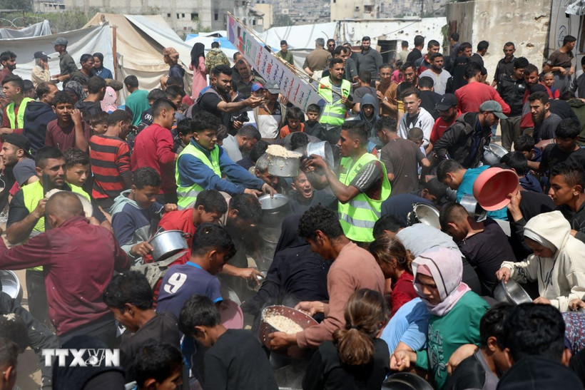 Người dân Palestine nhận thức ăn cứu trợ tại thành phố Gaza ngày 2/5/2025. (Ảnh: THX/TTXVN)