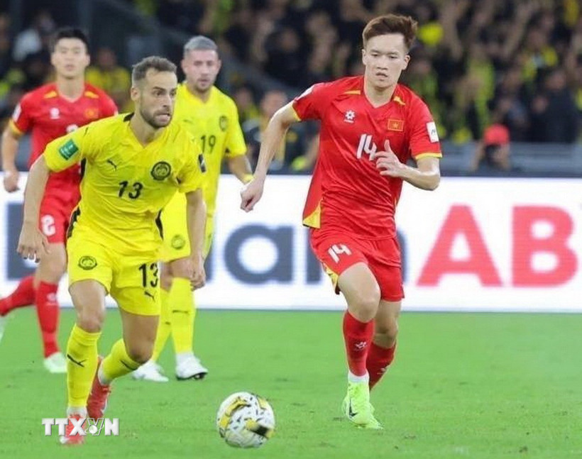 Nỗ lực đi bóng của Hoàng Đức (14-tuyển Việt Nam) trước các cầu thủ Malaysia. (Ảnh: TTXVN phát)