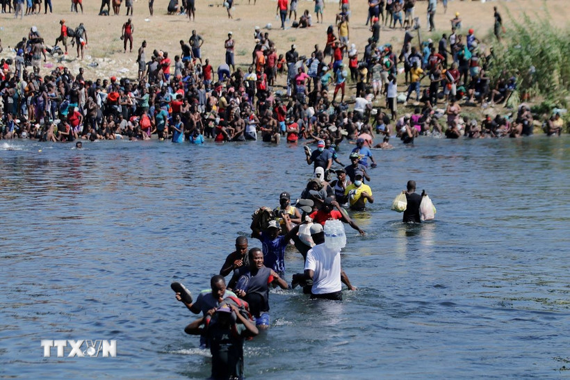 Người di cư vượt sông Rio Bravo ở biên giới Mỹ-Mexico. (Ảnh: THX/TTXVN)