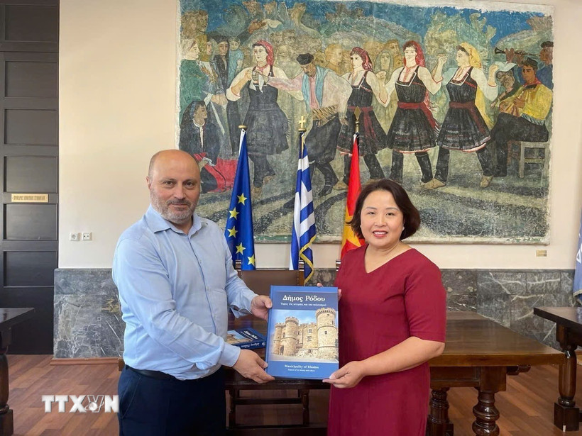 Phó Thị trưởng đảo Rhodes Chalkias Konstantinos tặng sách cho Đại sứ Phạm Thị Thu Hương. (Ảnh: TTXVN phát)