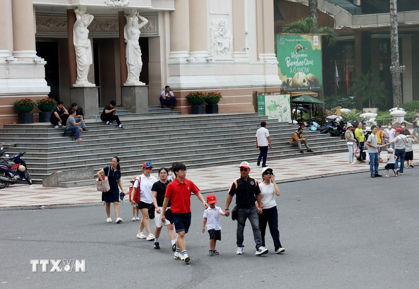 Du khách dạo chơi ở Quảng trường Lam Sơn, trước Nhà hát Thành phố Hồ Chí Minh. (Ảnh: Hồng Đạt/TTXVN)