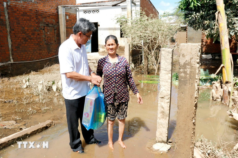 Phó Chủ tịch Ủy ban Nhân dân tỉnh Lâm Đồng Nguyễn Minh tặng quà, động viên người dân bị thiệt hại do ngập lụt tại xã Bắc Bình. (Ảnh: Nguyễn Thanh/TTXVN)