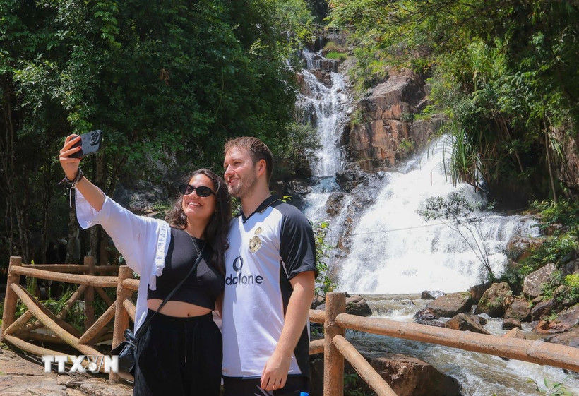 Du khách thích thú với phong cảnh thiên nhiên thác Datanla. (Ảnh: Hoàng Hiếu/TTXVN)