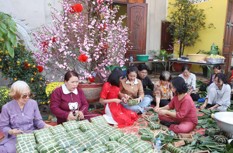 Các bạn trẻ người Lào hào hứng và phấn khỏi khi được tự tay gói bánh chưng nhân dịp Tết Cổ truyền của Việt Nam. (Ảnh: Xuân Tú/TTXVN)