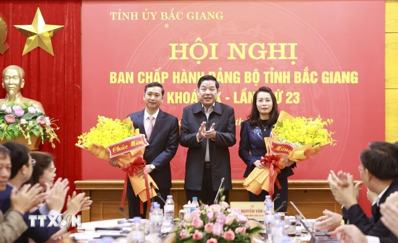 Bí thư Tỉnh ủy Bắc Giang Nguyễn Văn Gấu tặng hoa chúc mừng Phó Bí thư Thường trực Tỉnh uỷ Nguyễn Thị Hương (phải) và Phó Bí thư Tỉnh ủy Nguyễn Việt Oanh (trái). (Ảnh: TTXVN phát)