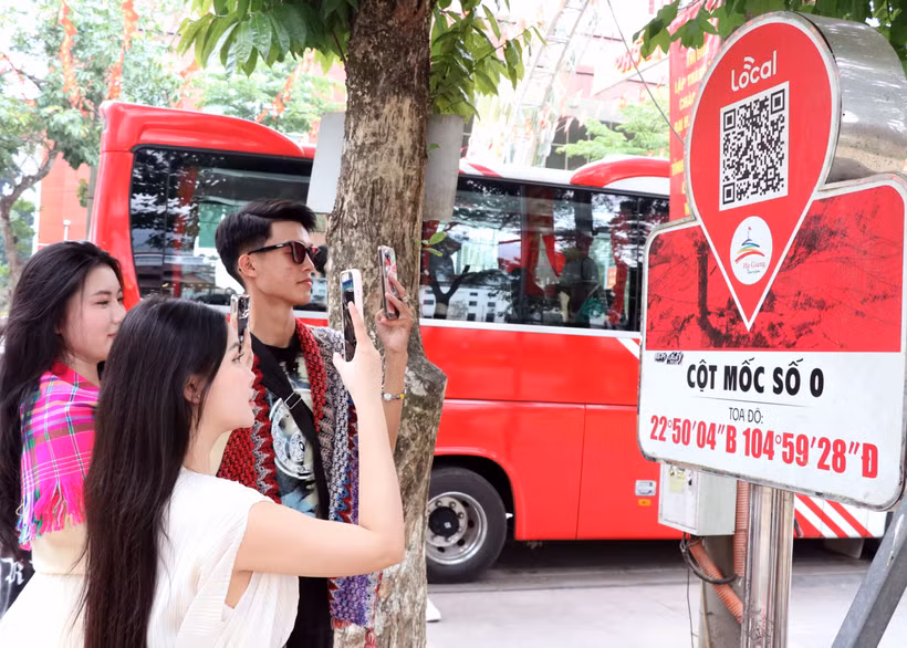 Du khách quét QR tại Km0 Hà Giang tìm hiểu thông tin du lịch. (Ảnh: Đức Thọ/TTXVN)