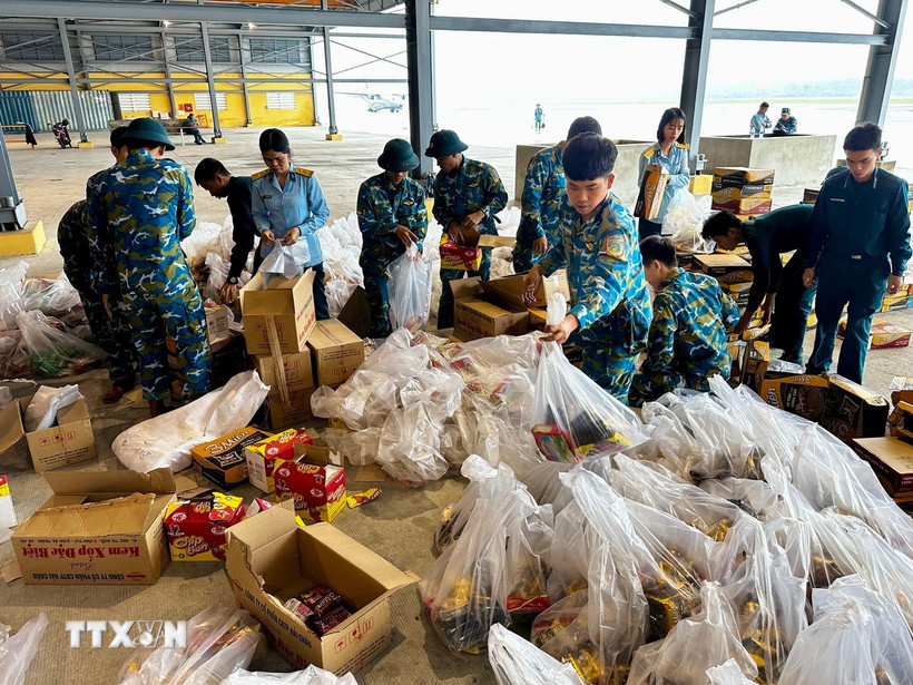 Lương thực, thực phẩm, nhu yếu phẩm được sắp xếp lên máy bay để chuyển đến người dân vùng lũ. (Ảnh: Trần Lê Lâm/TTXVN)