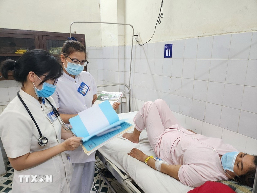Bác sỹ, điều dưỡng Khoa Bệnh nhiệt đới, Bệnh viện Trung ương Huế kiểm tra, theo dõi sức khỏe bệnh nhân mắc liên cầu lợn. (Ảnh: Mai Trang/TTXVN)