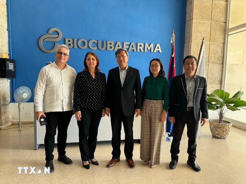 Đại sứ Lê Quang Long và Chủ tịch BioCubaFarma Mayda Mauri Pérez chụp ảnh cùng đại diện BioCubaFarma và cán bộ Đại sứ quán Việt Nam tại Cuba. (Ảnh: Việt Hùng/TTXVN)