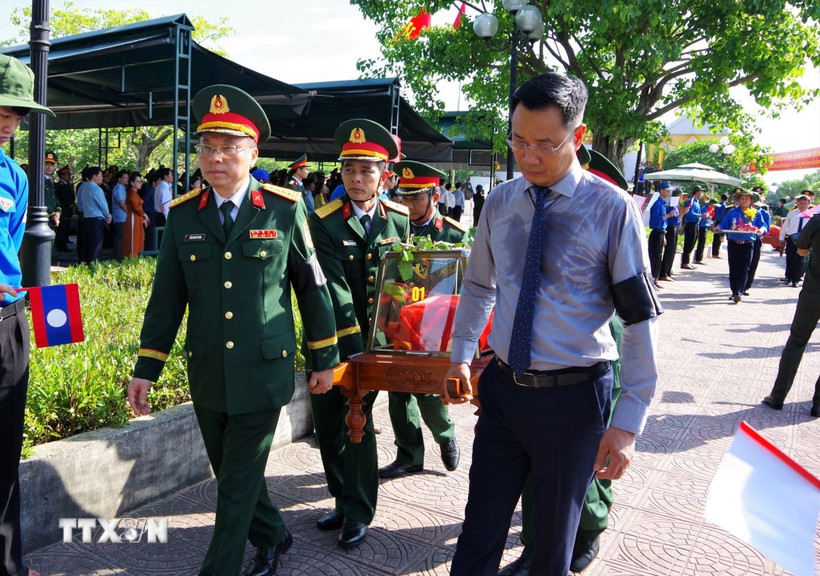 Bí thư Tỉnh ủy Quảng Bình Lê Ngọc Quang (phải) tham gia lễ an táng hài cốt liệt sỹ. (Ảnh: Tá Chuyên/TTXVN)