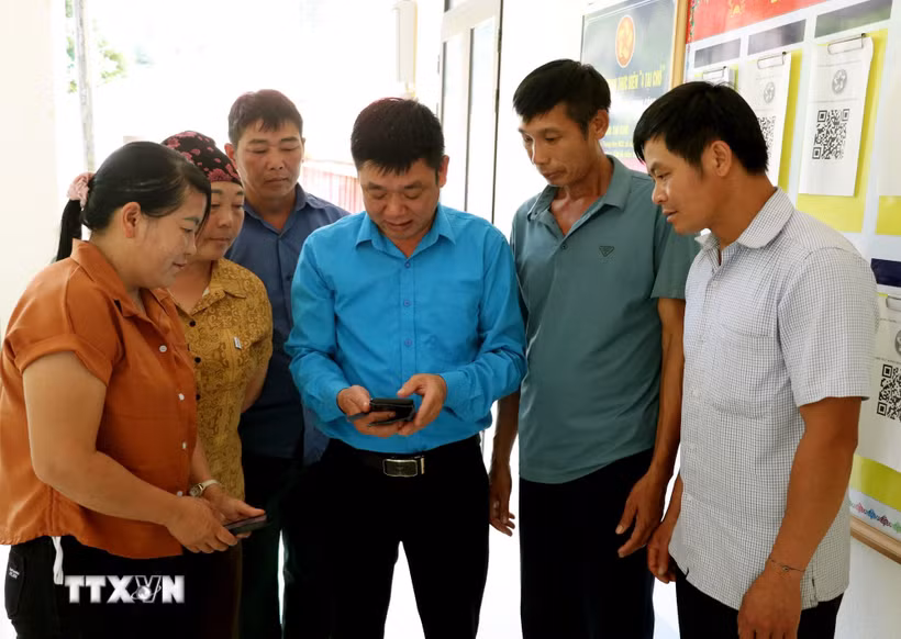 Cán bộ xã Lao Chải (Tuyên Quang) hướng dẫn người dân cài đặt, sử dụng các ứng dụng số và thực hiện thủ tục hành chính trên môi trường điện tử, từng bước thúc đẩy chuyển đổi số ở vùng biên. (Ảnh: Đức Thọ/TTXVN)