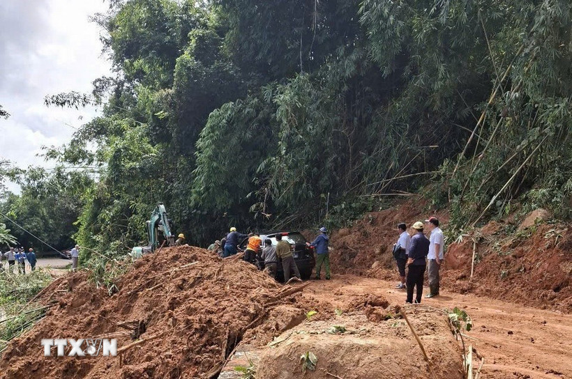 Lực lượng chức năng hỗ trợ phương tiện di chuyển qua điểm sạt lở sau khi đã cơ bản giải phóng hiện trường trong sáng 28/10. (Ảnh: TTXVN phát)