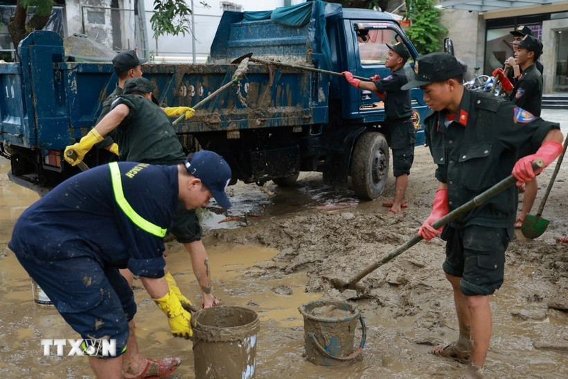 Đoàn công tác Công an tỉnh Quảng Trị có mặt tại thành phố Huế và khẩn trương tiến hành dọn vệ sinh môi trường, đẩy bùn đất tại các cơ quan, đơn vị. (Ảnh: TTXVN phát)
