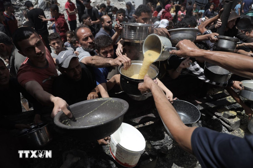 Người dân Palestine nhận thức ăn cứu trợ tại trại tị nạn Jabalia, miền Bắc Dải Gaza ngày 19/5. (Ảnh: THX/TTXVN)