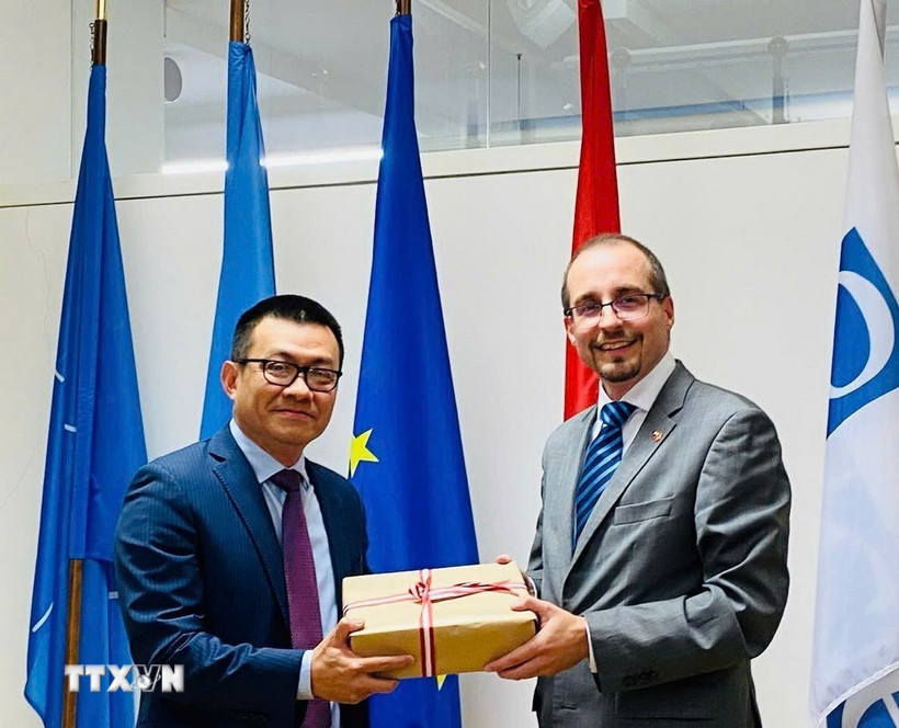 Ông Vũ Lê Thái Hoàng (trái), Đại sứ Việt Nam tại Cộng hòa Áo, trao quà lưu niệm cho Tiến sỹ Arnold Kammel, Thứ trưởng thường trực Bộ Quốc phòng Áo. (Ảnh: TTXVN)