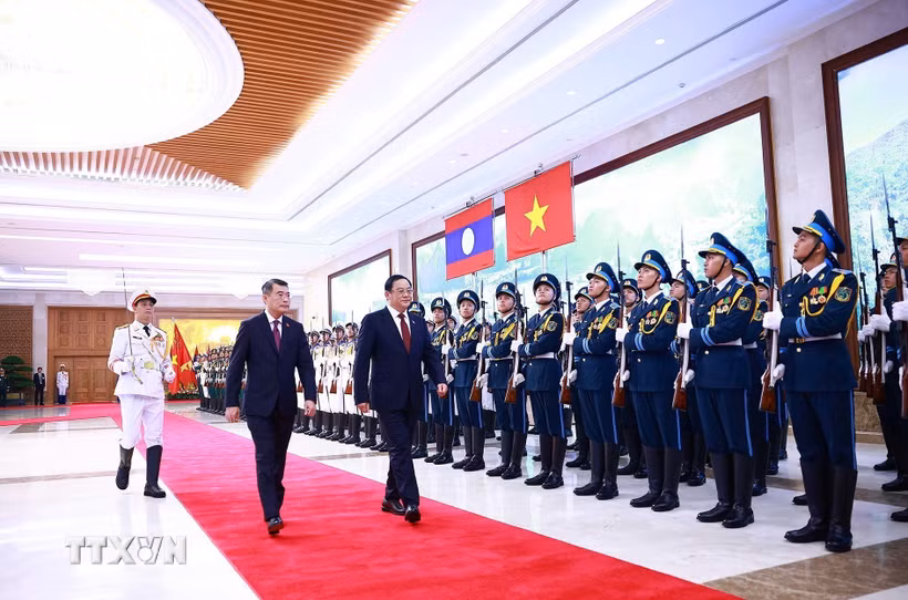 Thủ tướng Lê Minh Hưng và Thủ tướng Lào Sonexay Siphandone duyệt Đội danh dự Quân đội nhân dân Việt Nam. (Ảnh: Dương Giang/TTXVN)