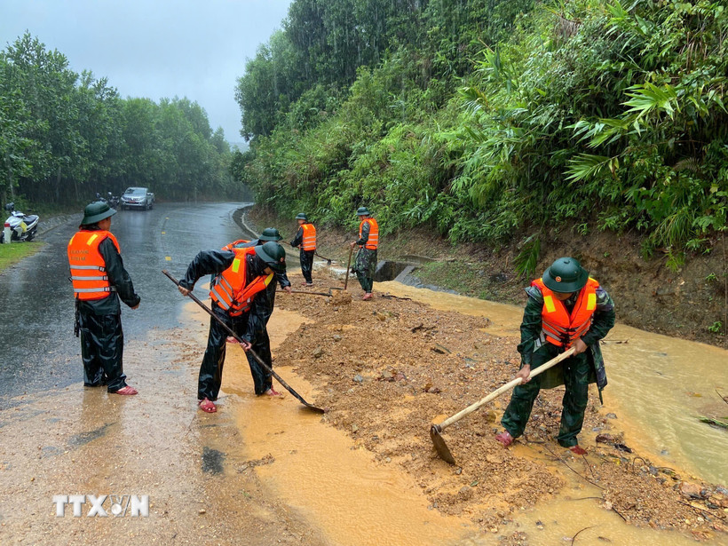 Bộ đội biên phòng thành phố Huế đào xúc đất đá, san gạt mặt đường bị sạt lở đất tại đèo Pê Kê, xã A Lưới 1. (Ảnh: Mai Trang/TTXVN)