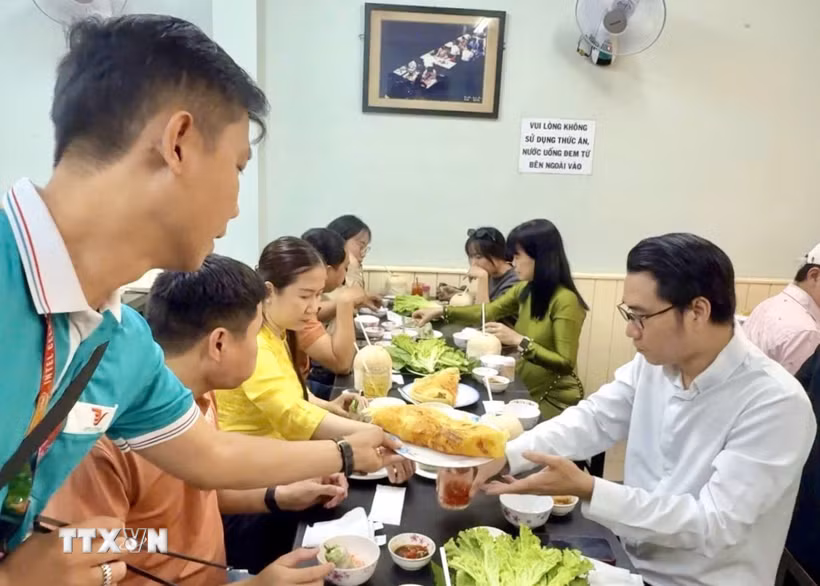 Du khách thưởng thức ẩm thực địa phương đặc trưng trong tour du lịch Thành phố Hồ Chí Minh. (Ảnh: Mỹ Phương/TTXVN)