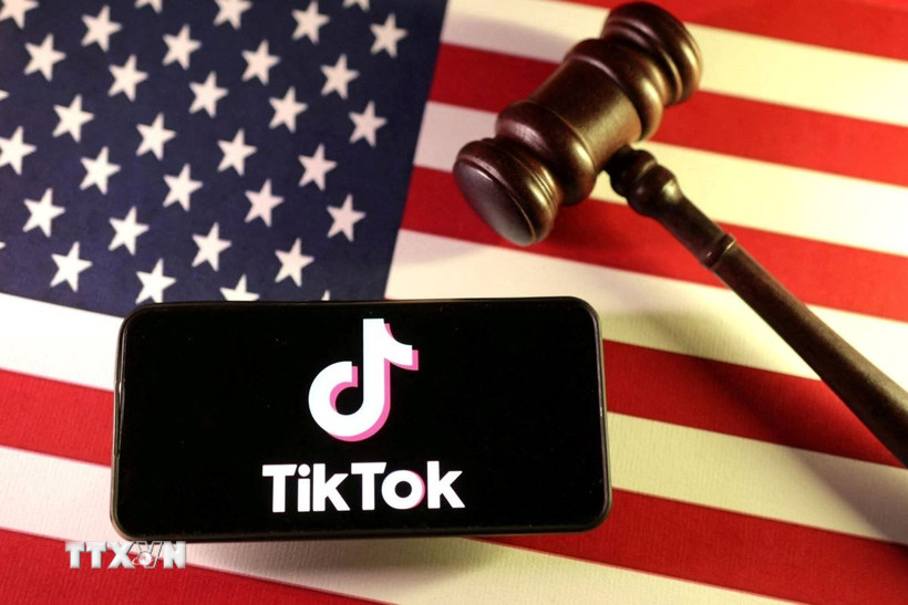 Logo của ứng dụng TikTok trên điện thoại và quốc kỳ Mỹ. (Ảnh: Reuters/TTXVN)
