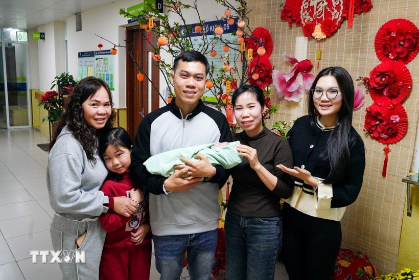 Niềm hạnh phúc của cả gia đình vợ chồng anh Nguyễn Văn Hùng và chị Vũ Thảo Phương khi được đón thành viên mới. (Ảnh: Khánh Hòa/TTXVN)