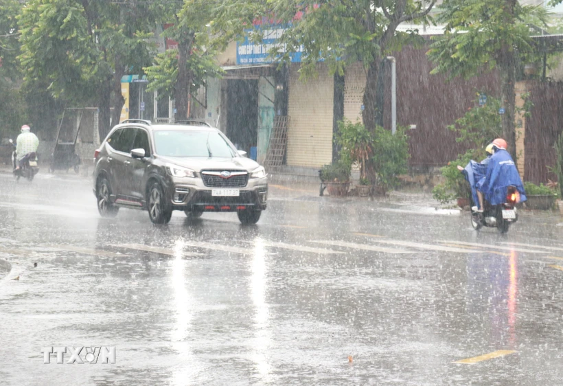 Người dân đi lại trong mưa lớn ở thành phố Đông Hà, tỉnh Quảng Trị. (Ảnh: Nguyên Lý/TTXVN)