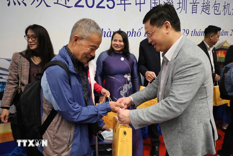 Các hành khách trên chuyến bay DZ6355 được lãnh đạo thành phố Huế trao hoa và tặng quà lưu niệm chúc mừng. (Ảnh: Văn Dũng/TTXVN)