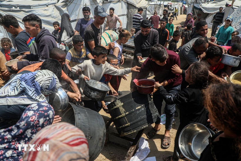 Người dân Palestine chờ được phát thực phẩm cứu trợ tại Gaza. (Ảnh: THX/TTXVN)