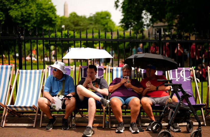 Người dân dùng ô che nắng ở London. (Ảnh: PA)