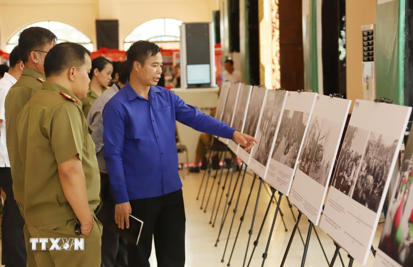 Cán bộ Đoàn và sỹ quan công an Lào tham quan khu trưng bày ảnh về Chiến dịch Hồ Chí Minh lịch sử của Việt Nam. (Ảnh: Xuân Tú/TTXVN)
