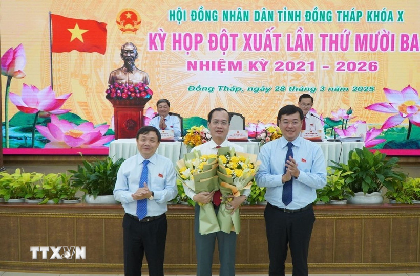Bí thư Tỉnh ủy Đồng Tháp Lê Quốc Phong và Chủ tịch Hội đồng Nhân dân tỉnh Đồng Tháp Phan Văn Thắng tặng hoa chúc mừng ông Trần Trí Quang (giữa) được bầu giữ chức Chủ tịch Ủy ban Nhân dân tỉnh Đồng Tháp. (Ảnh: Nhựt An/TTXVN)