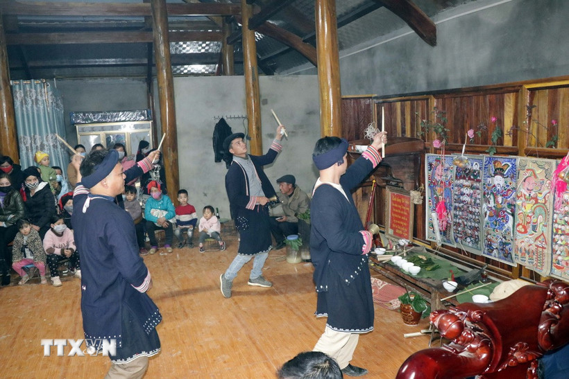 Trong ảnh: Thầy cúng và chủ nhà làm lễ trước ban thờ tổ tiên. (Ảnh: Hữu Quyết/TTXVN)