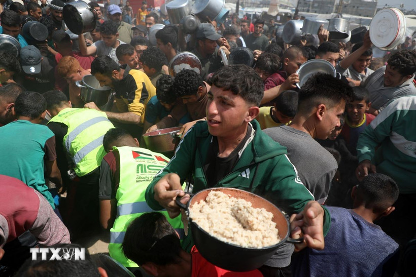 Người dân nhận thực phẩm cứu trợ tại Gaza. (Ảnh: THX/TTXVN)