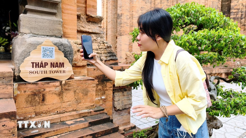 Du khách quét QR tìm hiểu thông tin tại Di tích quốc gia đặc biệt Tháp Bà Pô Nagar (phường Bắc Nha Trang, Khánh Hòa). (Ảnh: Nguyễn Thành/TTXVN)