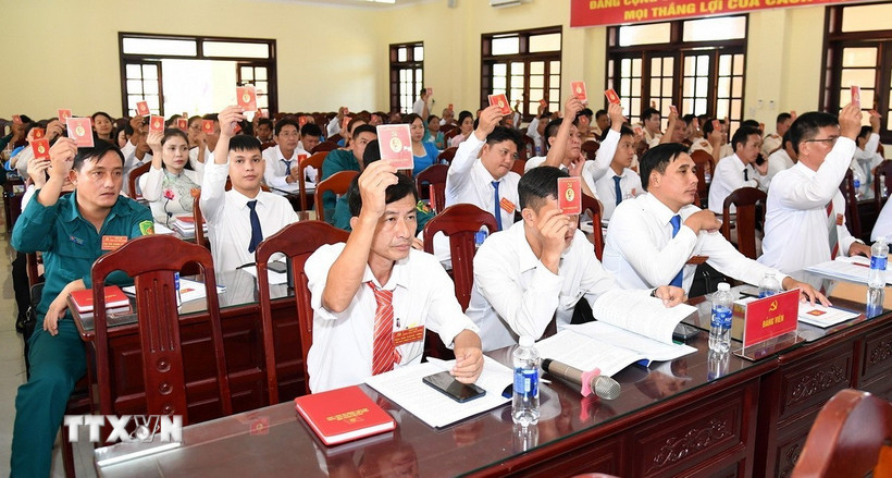 Các đại biểu biểu quyết thông qua dự thảo Nghị quyết Đại hội. (Ảnh: TTXVN phát)