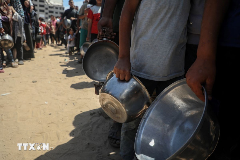 Người dân chờ được phát thực phẩm cứu trợ tại trại tị nạn al-Shati, Gaza. (Ảnh: THX/TTXVN)