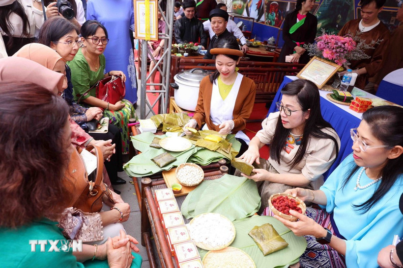 Bà Lê Thị Bích Trân, Phu nhân Thủ tướng Chính phủ Phạm Minh Chính và nhóm Phụ nữ cộng đồng ASEAN tại Hà Nội trải nghiệm làm bánh phu thê. (Ảnh: Phạm Kiên/TTXVN)