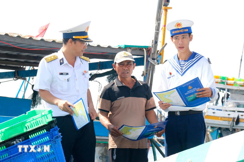 Cán bộ, chiến sỹ Lữ đoàn 681, Vùng 2 Hải quân, tuyên truyền cho ngư dân về phòng chống vi phạm khai thác hải sản bất hợp pháp, không báo cáo và không theo quy định (IUU). (Ảnh: Nguyễn Thanh/TTXVN)