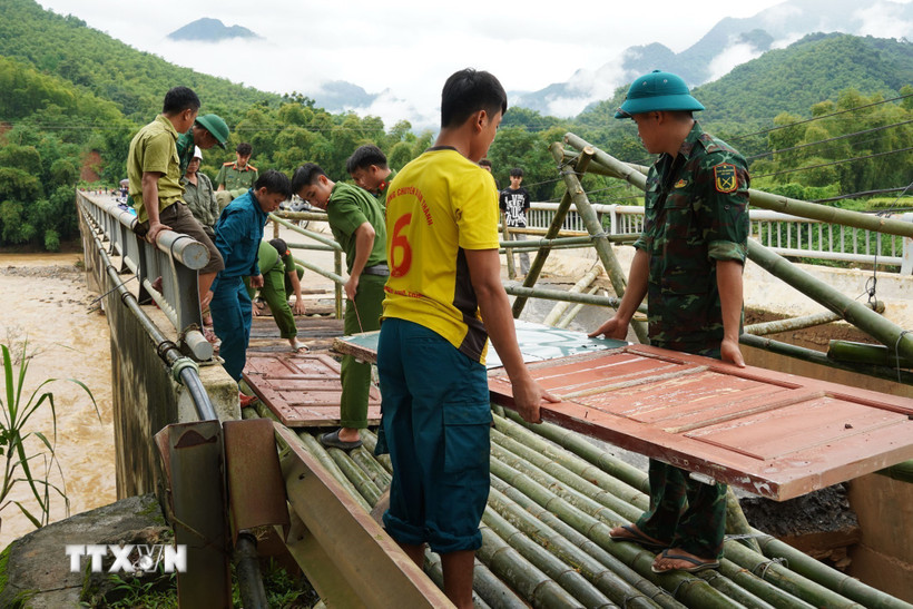 Người dân và chính quyền đã kịp thời khắc phục sự cố đầu Cầu Sơn Thủy trên Quốc lộ 16 tại lý trình Km89+580 tại bản Chung Sơn bị hư hỏng nặng chân, mố cầu, và bị sập hoàn toàn mặt đường nhựa dài hơn 10 mét. (Ảnh: TTXVN phát)