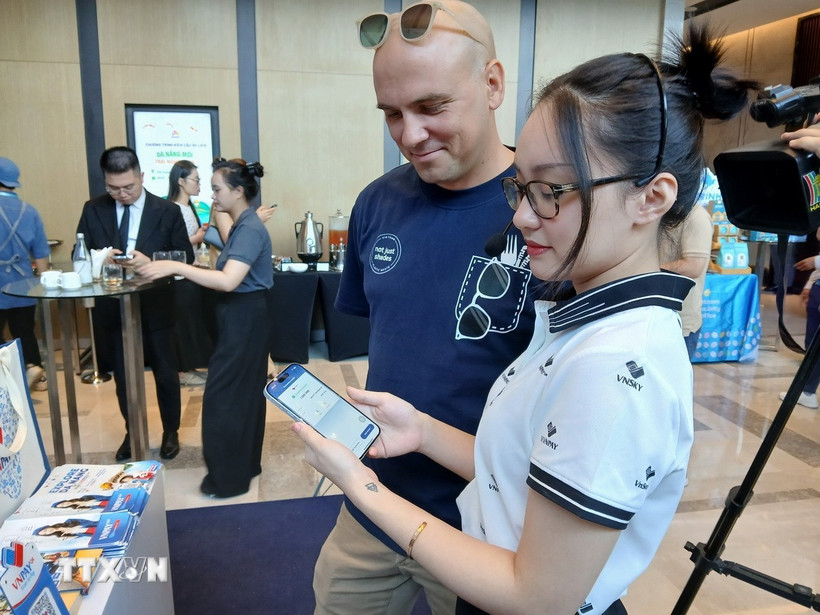 Giới thiệu phần mềm ứng dụng ví điện tử du lịch thông minh đến du khách quốc tế. (Ảnh: Mỹ Hà/TTXVN)