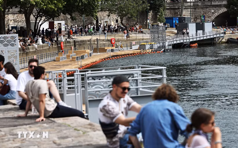 Người dân tránh nóng bên bờ sông Seine tại Paris, Pháp. (Ảnh: THX/TTXVN)