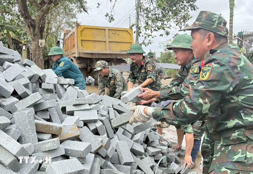 Chiến sỹ Đoàn Kinh tế-Quốc phòng 207/Quân khu 5 vận chuyển vật liệu xây sửa nhà cho người dân. (Ảnh: Tường Quân/TTXVN)